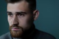 Close-up portrait of a young handsome bearded guy looking to the side. A dramatic portrait. psychological, studio portrait on a