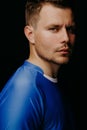 Close-up portrait of young handsome football player soccer posing on black dark background. Royalty Free Stock Photo