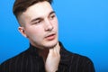 Close up portrait of young handsome man with modern hairstyle. Emotional face, slight beard, black striped shirt. Royalty Free Stock Photo