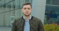 Close-up portrait of young handsome man standing outdoors alone smiling looking at camera. Beautiful people, city Royalty Free Stock Photo