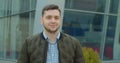 Close-up portrait of young handsome man standing outdoors alone smiling looking at camera. Beautiful people, city Royalty Free Stock Photo