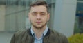 Close-up portrait of young handsome man standing outdoors alone smiling looking at camera. Beautiful people, city Royalty Free Stock Photo