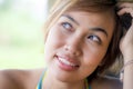 Close up portrait of young happy beautiful Asian woman from Indonesia looking thoughtful and pensive daydreaming and thinking Royalty Free Stock Photo