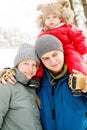 Close-up portrait of young happy family with one toddler in winter casual oufit