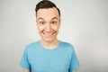 Close up portrait of young happy smiling guy, dressed in a blue t shirt on a light background Royalty Free Stock Photo