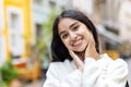 Close-up portrait of a young Indian woman walking on a city street in a stormy weather, holding her hands on her face Royalty Free Stock Photo