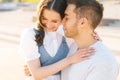 Close-up portrait of young loving couple resting in city park sitting embracing on bench in summer sunny day. Royalty Free Stock Photo