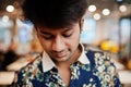 Close up portrait of young male indian freelancer in fast food cafe, handsome head of asian man wear in shirt at comfortable