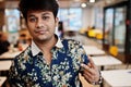 Close up portrait of young male indian freelancer in fast food cafe, handsome head of asian man wear in shirt at comfortable