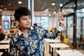 Close up portrait of young male indian freelancer in fast food cafe, handsome head of asian man wear in shirt at comfortable