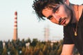 Close-up portrait of a young man in a black outfit in an industrial zone