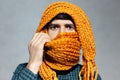 Close-up portrait of young man with dark yellow knitted scarf all over his face. Royalty Free Stock Photo