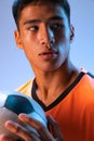 Close-up portrait of young man, professional football player posing isolated over blue studio background in neon light Royalty Free Stock Photo