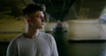 Close-up portrait of a young man standing under a bridge near the river Seine, posing Royalty Free Stock Photo