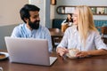Close-up portrait of young man and woman sitting in restaurant and working on laptop. Attractive blonde female sitting Royalty Free Stock Photo