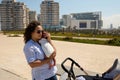 Young multi-ethnic woman, loving caring mother hugging her newborn baby, walking with buggy in the city Royalty Free Stock Photo