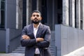 Close-up portrait of a young Muslim male lawyer in a business suit standing seriously outside a courthouse and looking Royalty Free Stock Photo