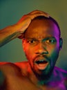 Close up portrait of a young naked african man looking at camera indoors Royalty Free Stock Photo