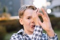 Close up portrait of a young naughty teenager man with a mischievous expression. Quirky young man outdoors. Royalty Free Stock Photo