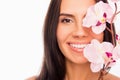 Close up portrait of young pretty woman covering half of her face with orchid Royalty Free Stock Photo