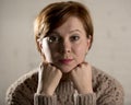 Close up portrait of young red hair sweet and beautiful Caucasian woman looking to the camera relaxed and tranquil smiling happy