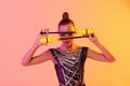 Close-up portrait of young rhythmic gymnastics artist in stage costume on gradient pink yellow studio