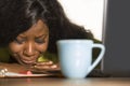 Close up portrait of young sad and depressed black afro American business woman crying while working at office computer desk feeli