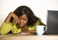 Close up portrait of young sad and depressed black afro American business woman crying while working at office computer desk feeli