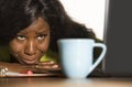 Close up portrait of young sad and depressed black afro American business woman crying while working at office computer desk feeli