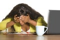 Close up portrait of young sad and depressed black afro American business woman crying while working at office computer desk feeli