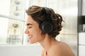 Close up portrait of young smiling woman, fitness girl in headphones, listens music and does workout training at home Royalty Free Stock Photo