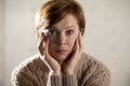 Close up portrait of young sweet and pretty red hair woman looking sad and depressed in dramatic face expression feeling lonely