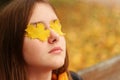 Close up portrait of young teenager girl relaxing and meditating outdoors in autumn park