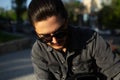 Close-up portrait of young thoughtful guy wearing sunglasses and black shirt. Outdoors photo. Royalty Free Stock Photo