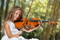 Close up Portrait of young violinist in woods. Royalty Free Stock Photo