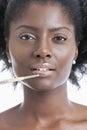 Close-up portrait of young woman applying lip gloss with brush Royalty Free Stock Photo