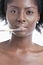 Close-up portrait of young woman applying lip gloss with brush Royalty Free Stock Photo