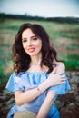 Close up Portrait of young woman in blue romantic dress with hat sitting on the stones. Calm and harmony. Summer vacation,fun,