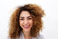 Close up young woman with curly hair smiling abasing white background