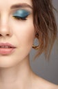 Closeup shot of human female face with eyes closed, yellow liner and blue eyes shadows Royalty Free Stock Photo