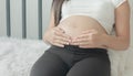 Close-up portrait Young woman  pregnant a beautiful sitting on the white bed Royalty Free Stock Photo