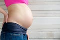 Close up portrait of a young woman showing pregnant stomach