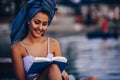 Close-up portrait of young woman sitting on the beach enjoying while reading a book Royalty Free Stock Photo