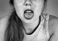 Close up portrait of young woman sticking out pierced tongue, showing her tongue piercing black and white Royalty Free Stock Photo