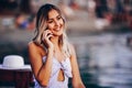 Close-up portrait of young woman talking on mobile phone and sitting on the beach Royalty Free Stock Photo