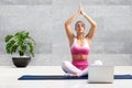 Young woman doing yoga at home in front of laptop Royalty Free Stock Photo
