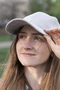 Close-up portrait of young womans face. Girl with brown hair and green eyes in sports cap. Vertical frame Royalty Free Stock Photo