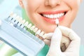 Close up portrait of Young women in dentist chair, Check and select the color of the teeth. Dentist makes the process of