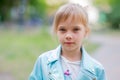 Close up portrait of young 6-7 year old girl. Girl 7 years old outdoors portrait in a blue jacket