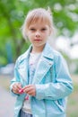 Close up portrait of young 6-7 year old girl. Girl 7 years old outdoors portrait in a blue jacket